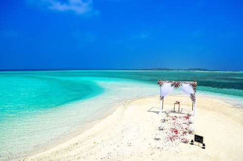 elope on a white sandy beach with turqoise coloured waters